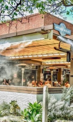 Outside view of Bardot restaurant with water mist coming out of the roof onto the outdoor patio where food is served.