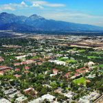 Overhead city view of Claremont city with mountain range in the back and blue sky above.