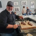 Owner cutting steaks at Claremont's The Meat Cellar restaurant.