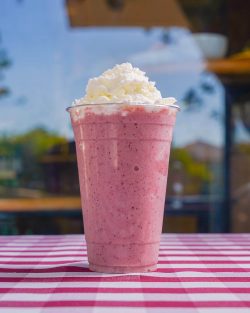 A delicious pink smoothie at Euro Cafe on a red checkered tablecloth.