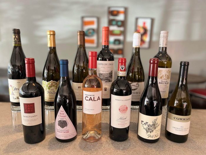 Enjoy a glass of red or white at one of the city's many charming cafes and atmospheric wine bars in Autumn during one of the events. 12 wine bottles are lined up on a counter.